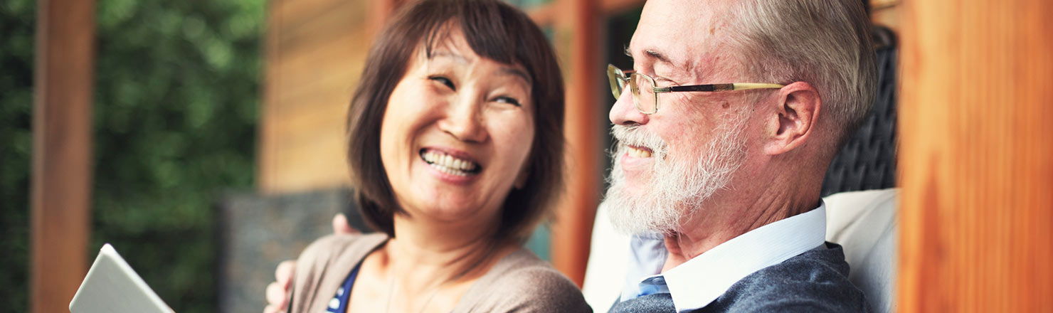 Mature couple with tablet on deck