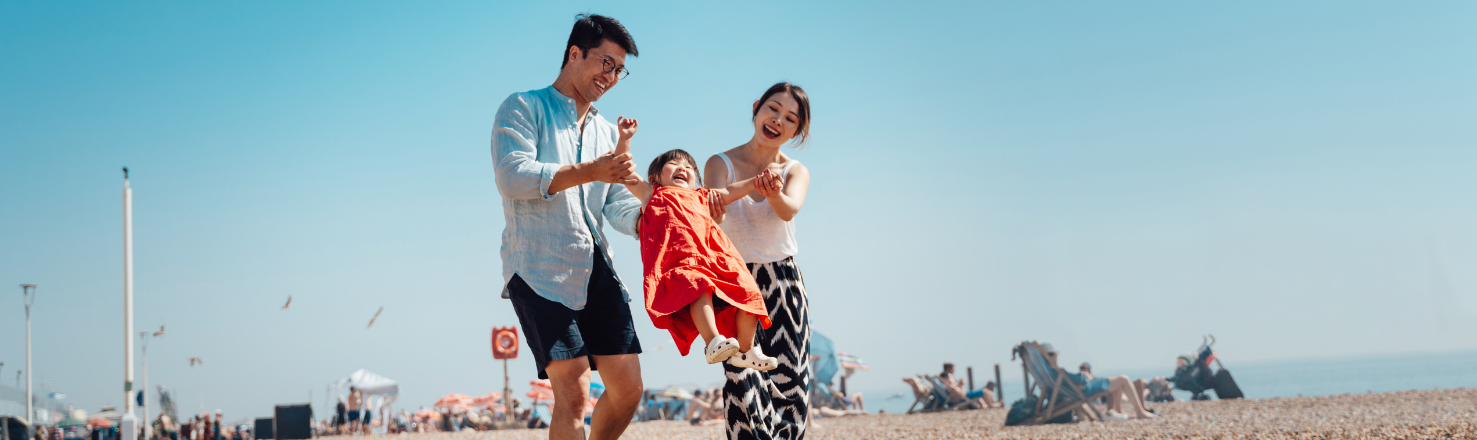 Young parents playing with their child on the beach 